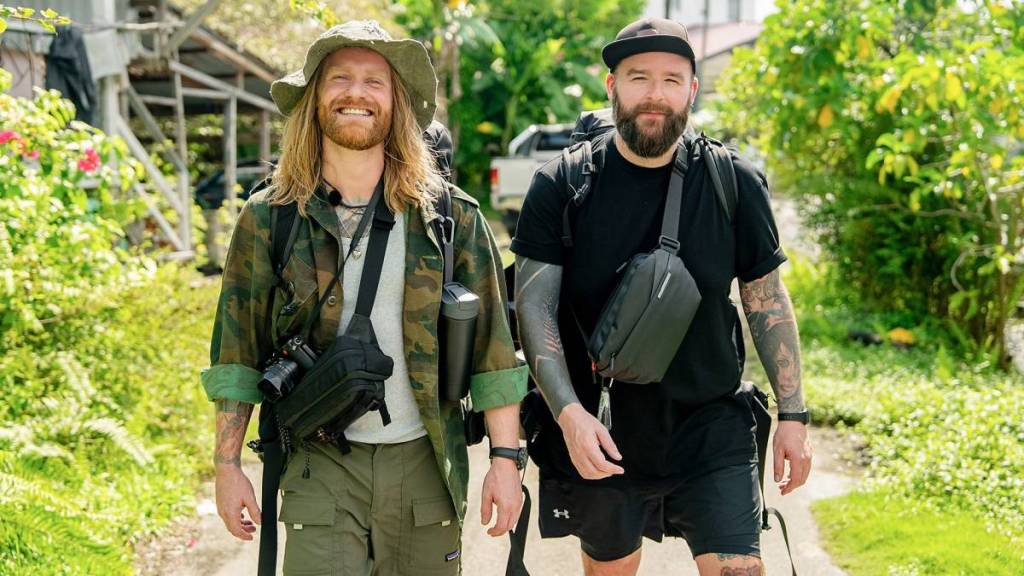 Sam Ryder und sein Freund Kaz lächeln, während sie in „Race Across the World“ auf die Kamera zugehen