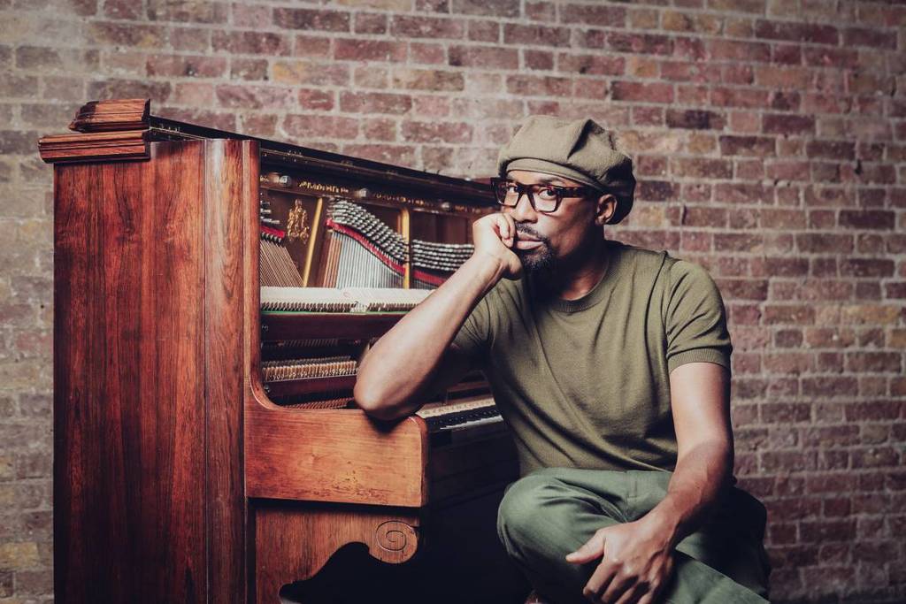 Alexis Ffrench shot leaning on a piano