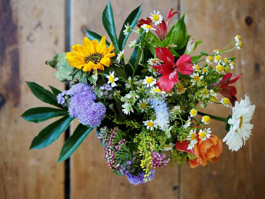 A bunch of flowers on a wooden table.