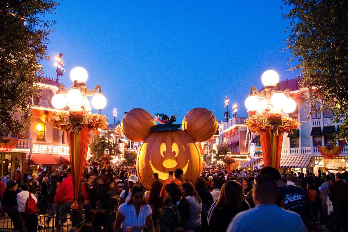 Crowds of people around a Mickey Mouse shaped pumpkin decoration at Disneyland.