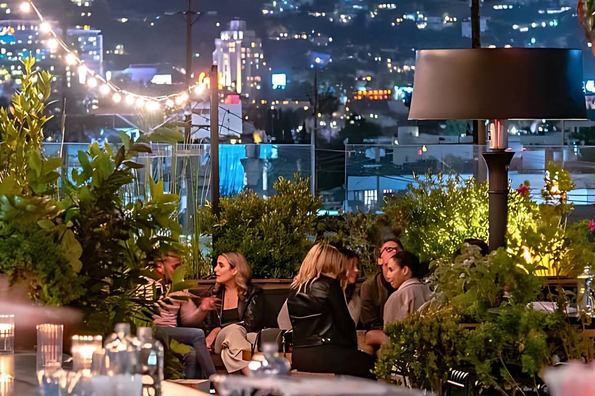 People having drinks at E.P. & L.P. Rooftop Bar at night