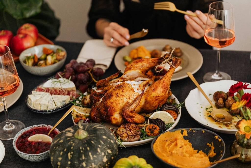 A Thanksgiving meal is set on a table with the turkey as the centerpiece.