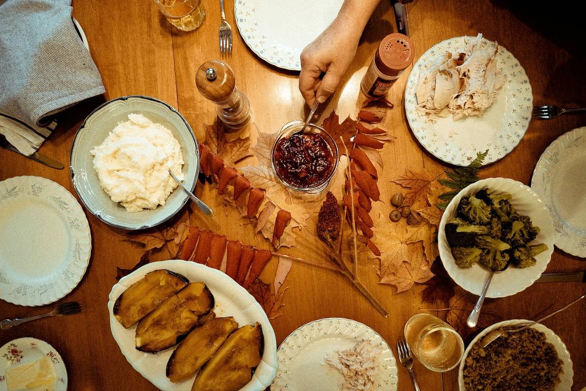 A table is filled with Thanksgiving sides.