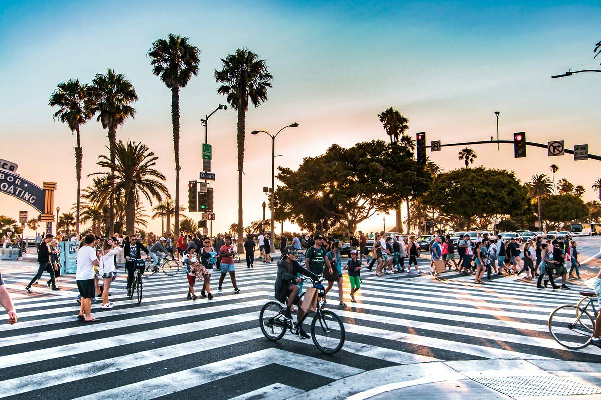 Une foule traverse le passage piéton devant la jetée de Santa Monica.
