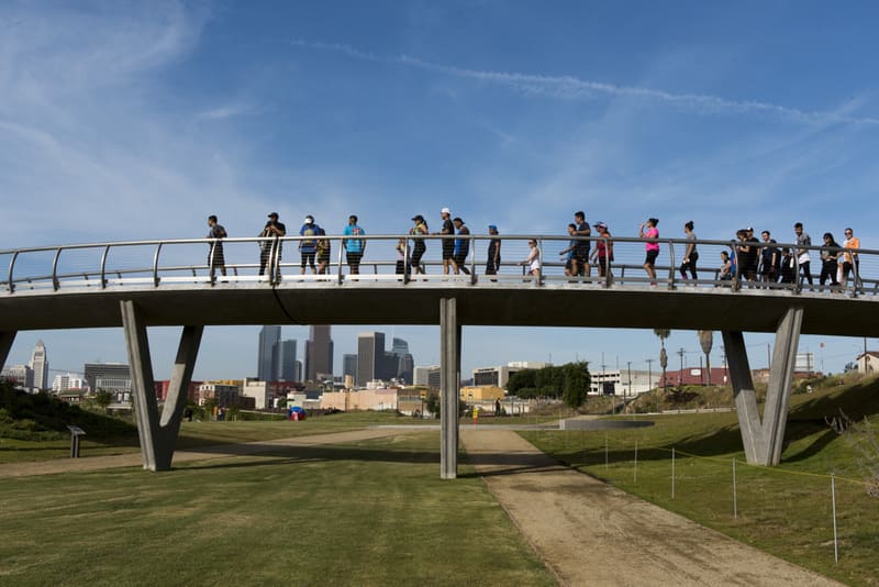 Des gens traversent un pont au-dessus du parc historique d'État de Los Angeles