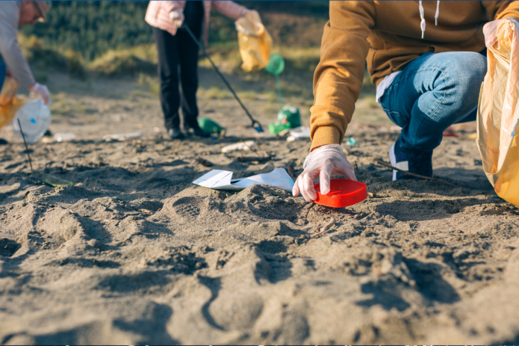 Leute, die an einem Strand Müll aufsammeln.