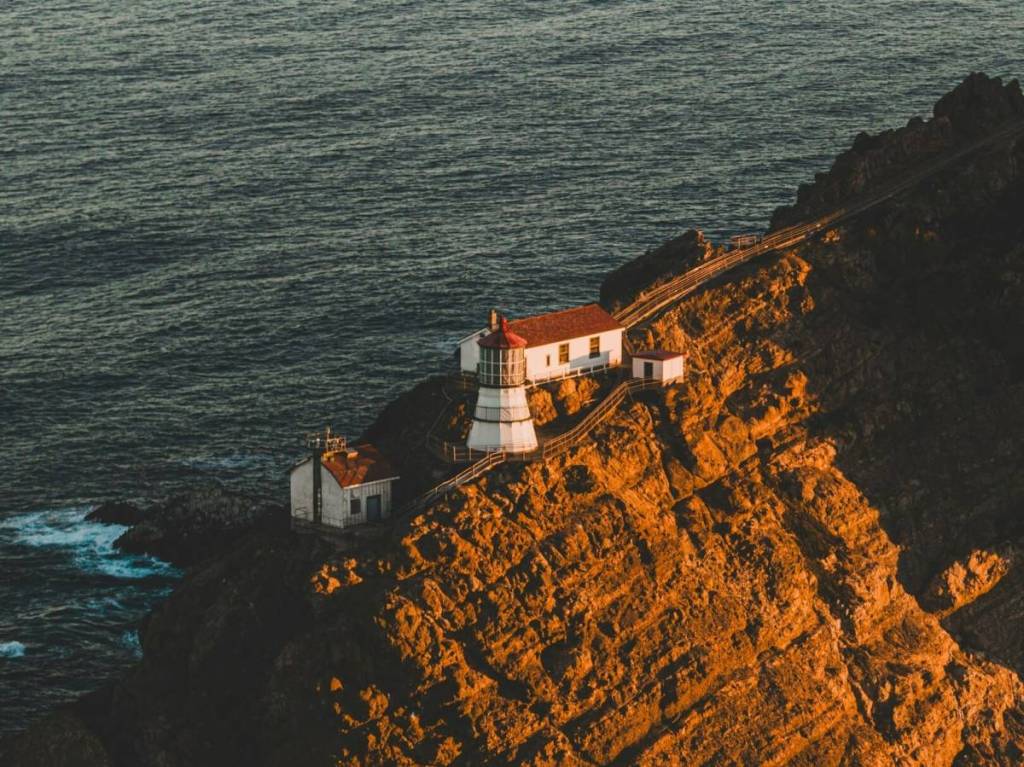 Der Point Reyes Leuchtturm thront bei Sonnenuntergang auf einem schroffen Felsvorsprung.