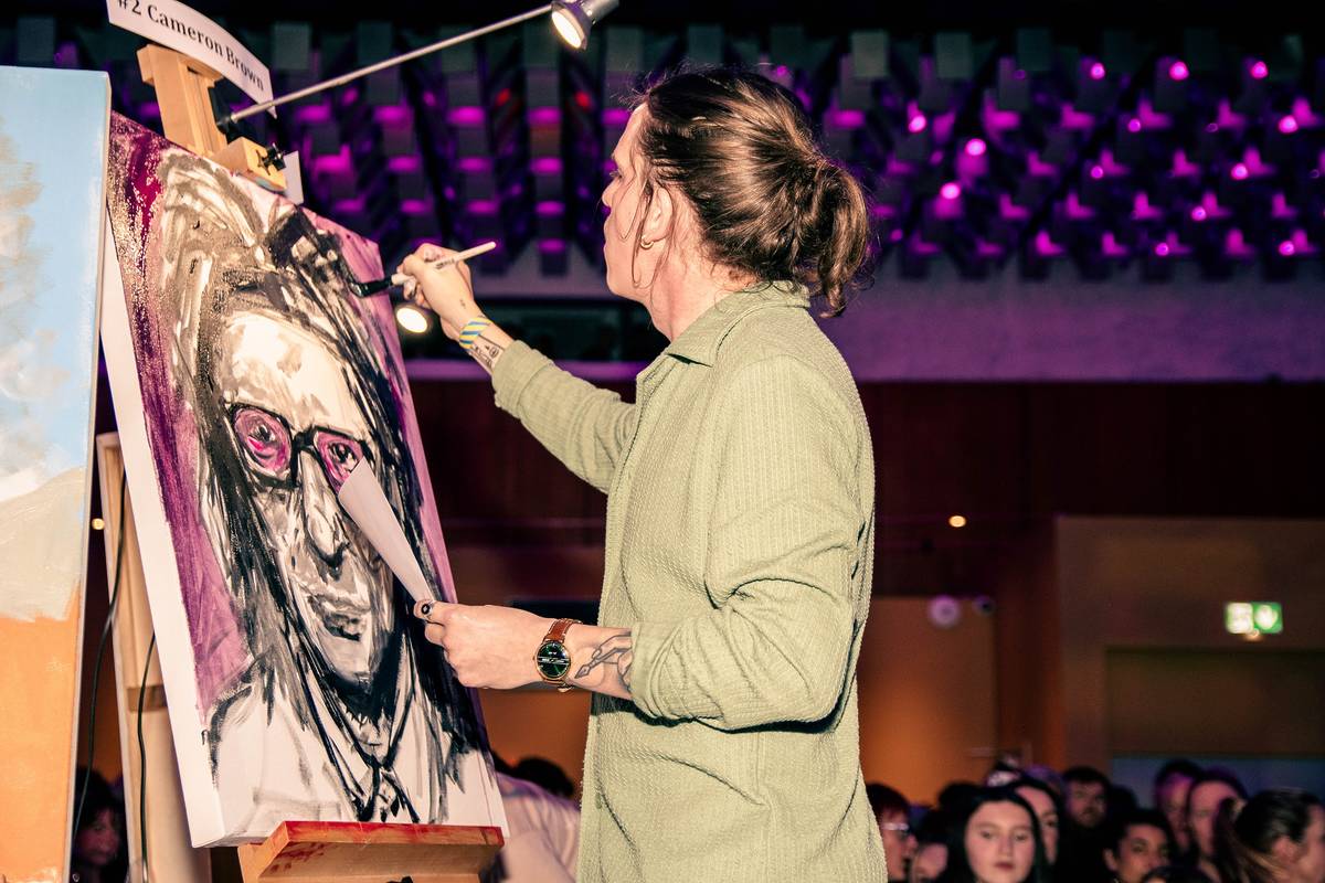 artist painting on canvas at art battle manchester