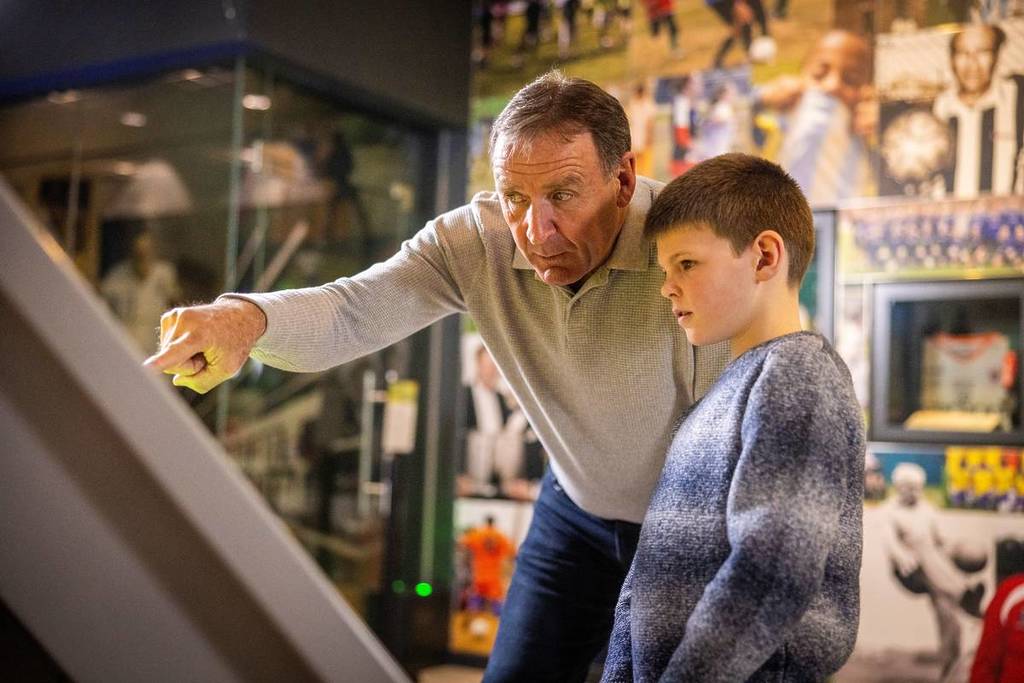 man and boy looking at display at national football museum