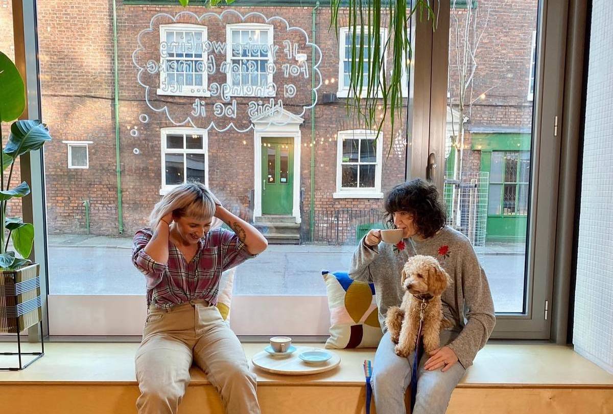 female-owned-feel-good-club-window-ladies-with-dog-on-lap-manchester