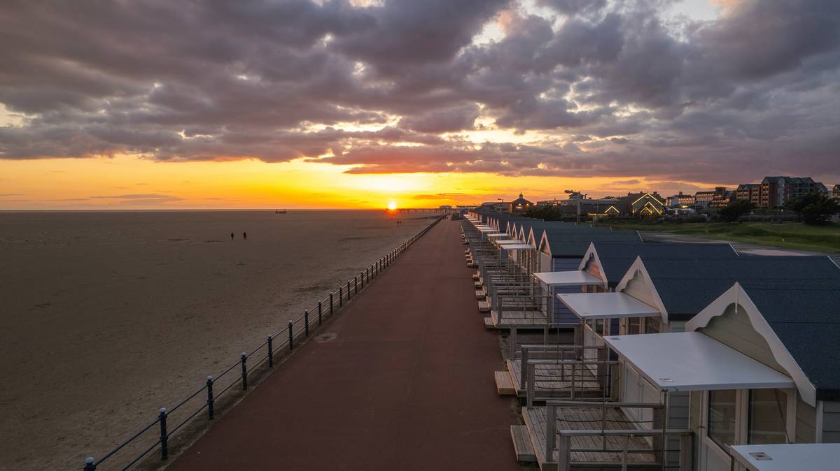 rows of beach huts at lytham st annes beach at sunset