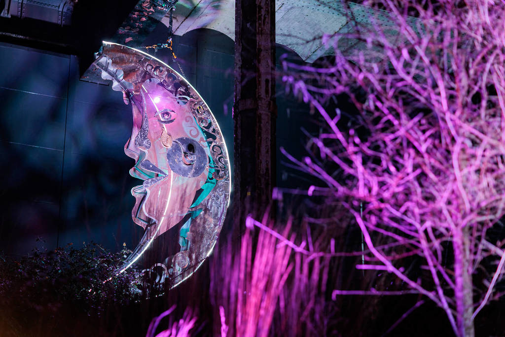 glowing half moon face in forest area of tiwlight tales light trail in mayfield park, manchester