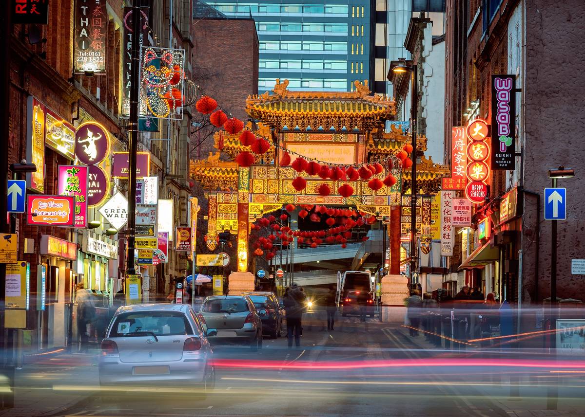 manchester chinatown archway with red lanterns strung across the street from building to building