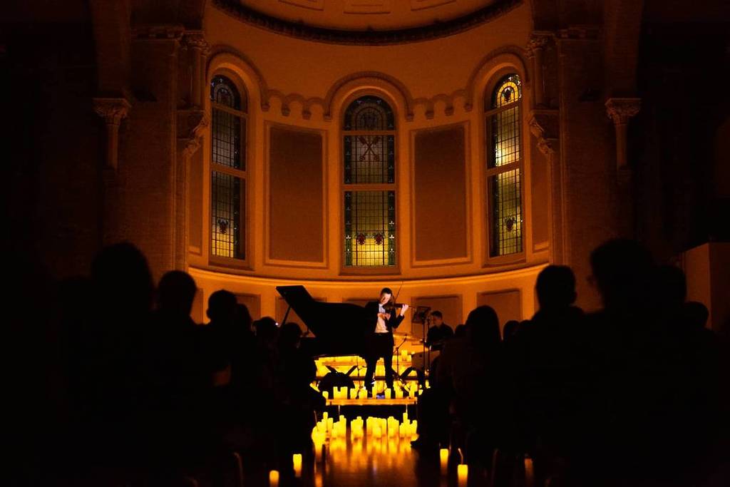 An audience watching a Candlelight piano concert at Halle St. Peter's in Manchester