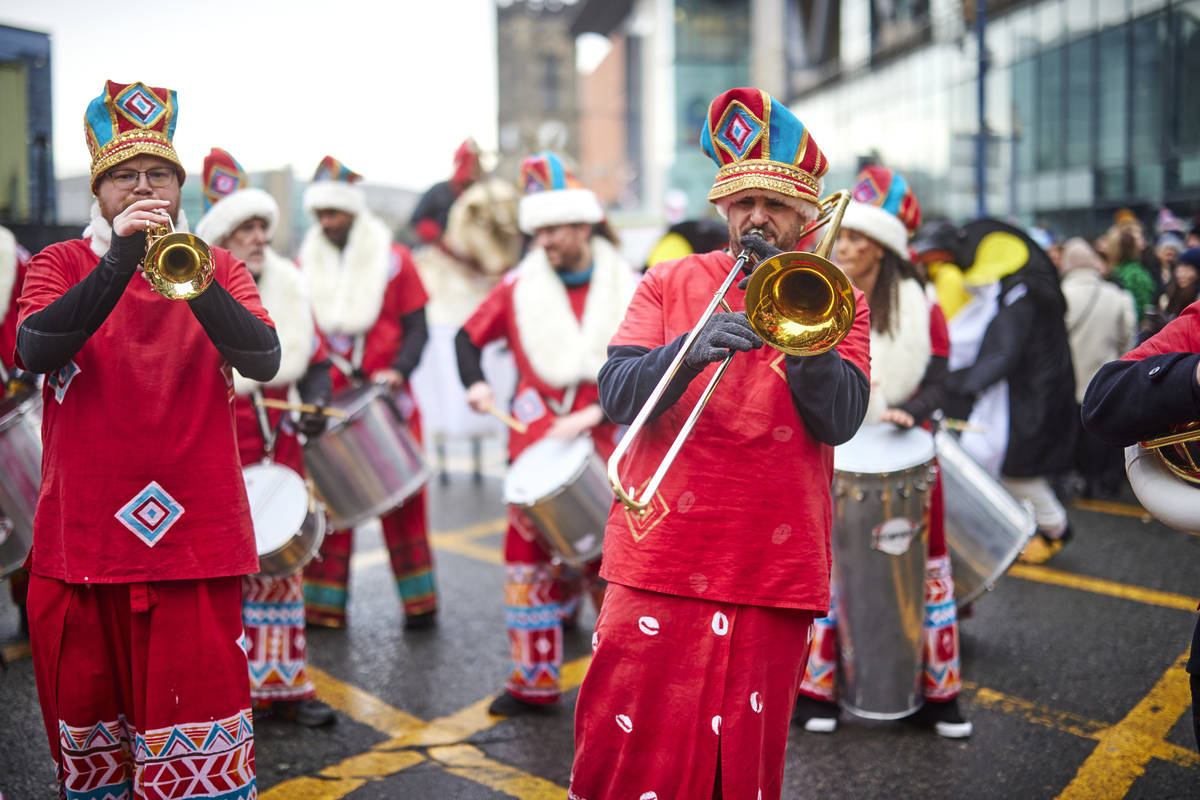 musicians walking down street as part of manchester christmas parade