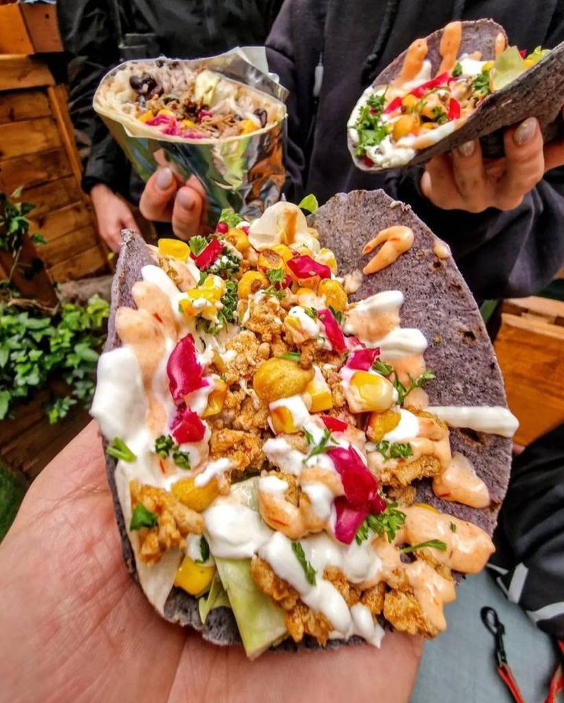 taco-fest-at-grub-mcr-black-taco-shells-with-colourful-filling-held-up-to-camera