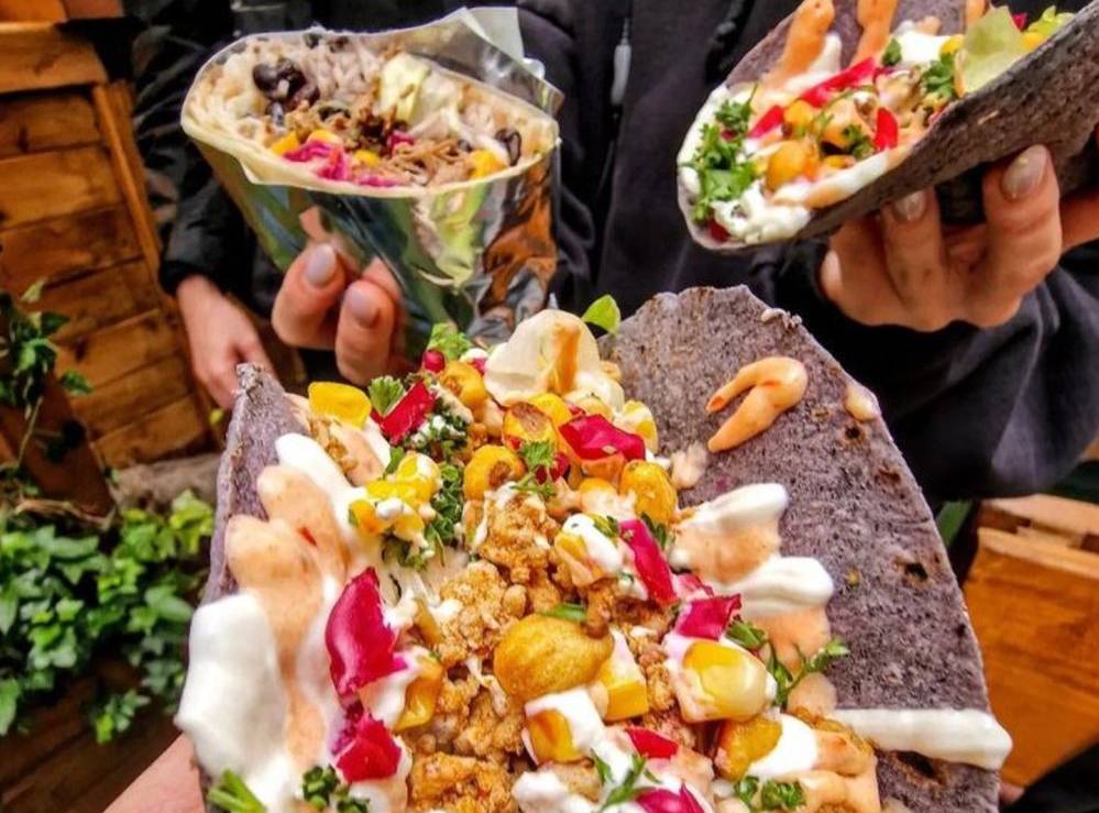 taco-fest-at-grub-mcr-black-taco-shells-with-colourful-filling-held-up-to-camera