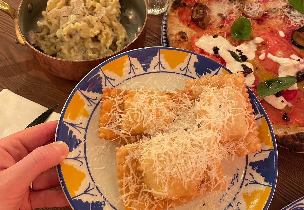 crispy cheese bites with parmesan on top next to creamy truffle pasta and veggie pizza