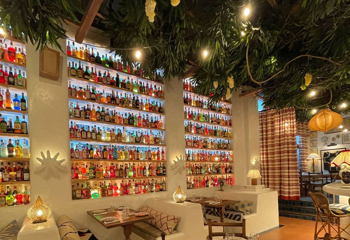 booth seating at circolo popolare manchester with different spirit bottles all stacked on shelves on walls