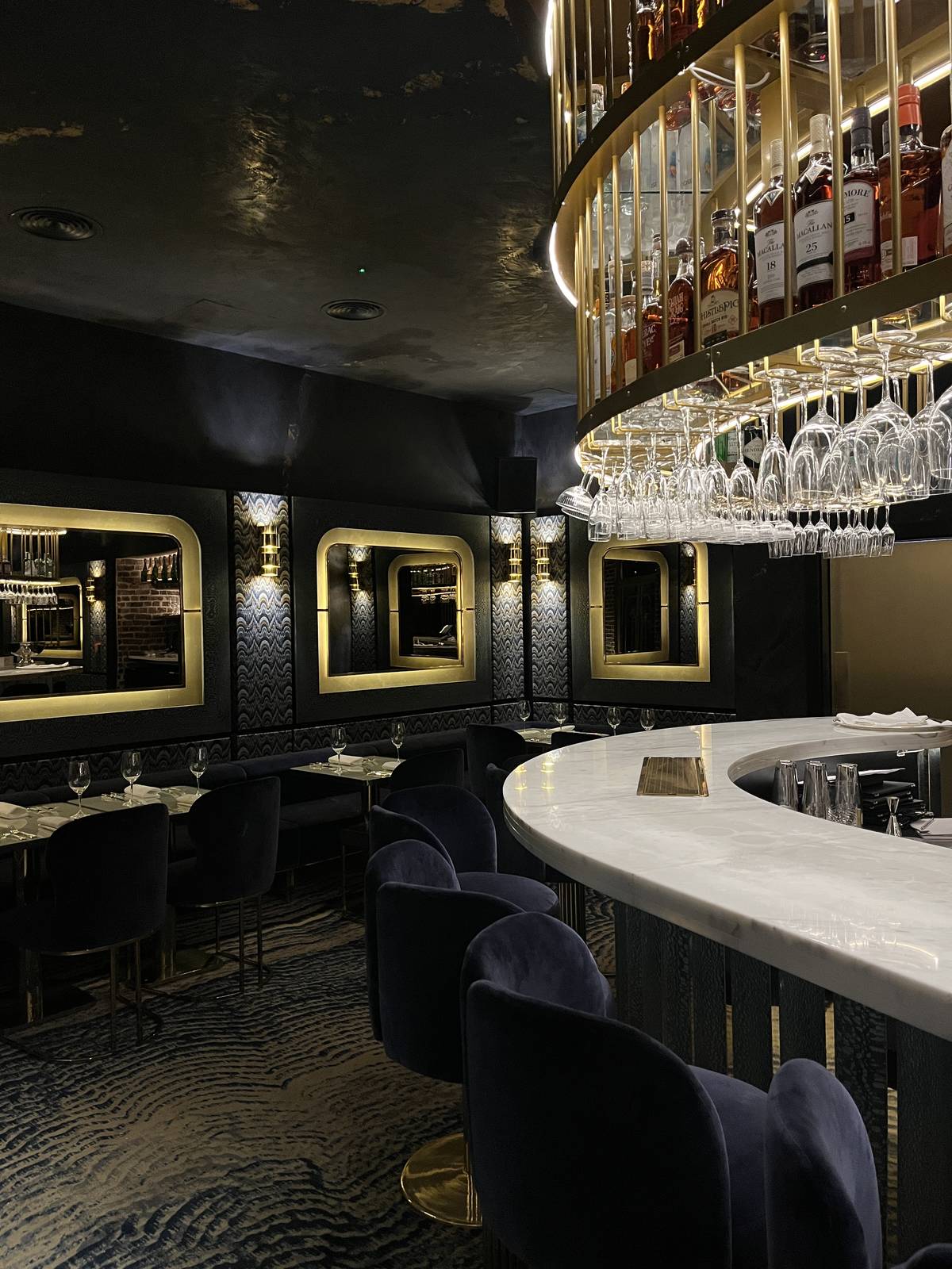 curved bar area with glasses hung above at maya manchester