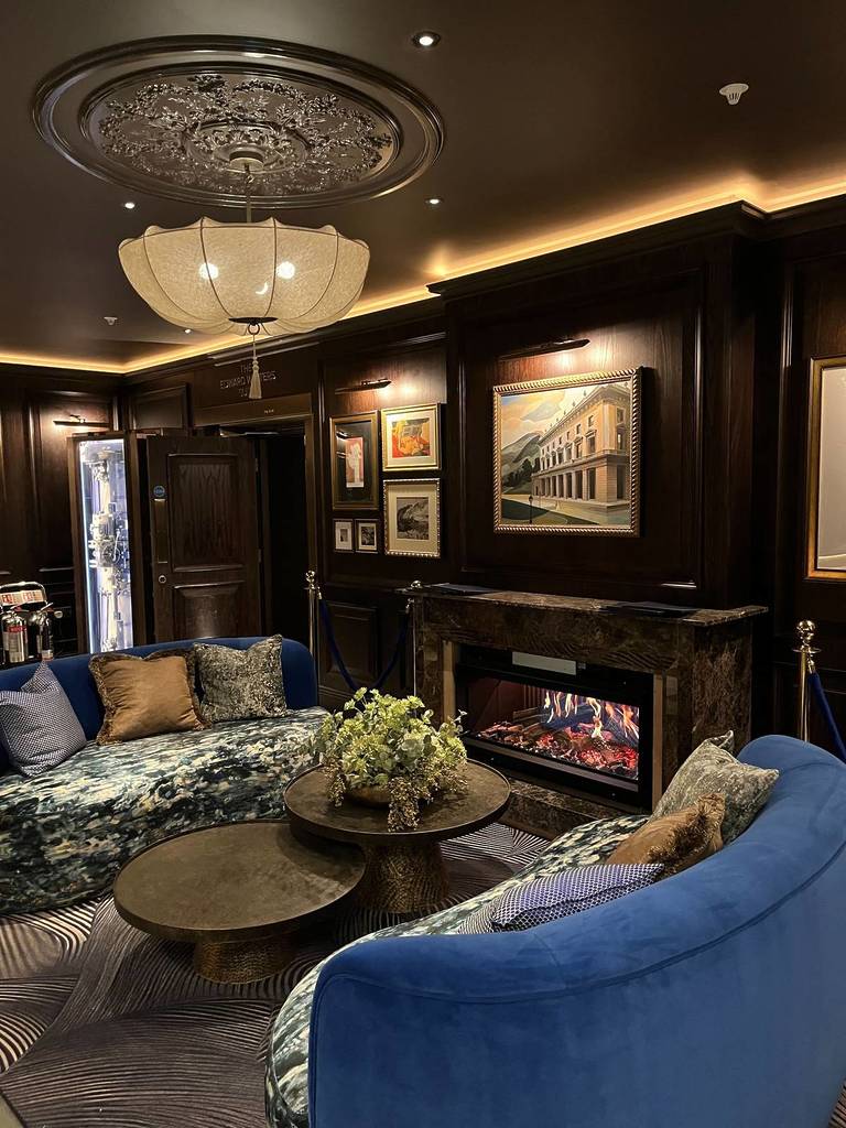 lounge area with blue sofa and chandelier from ceiling