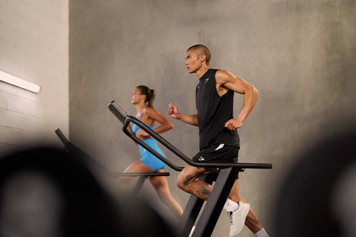woman and man running on treadmills