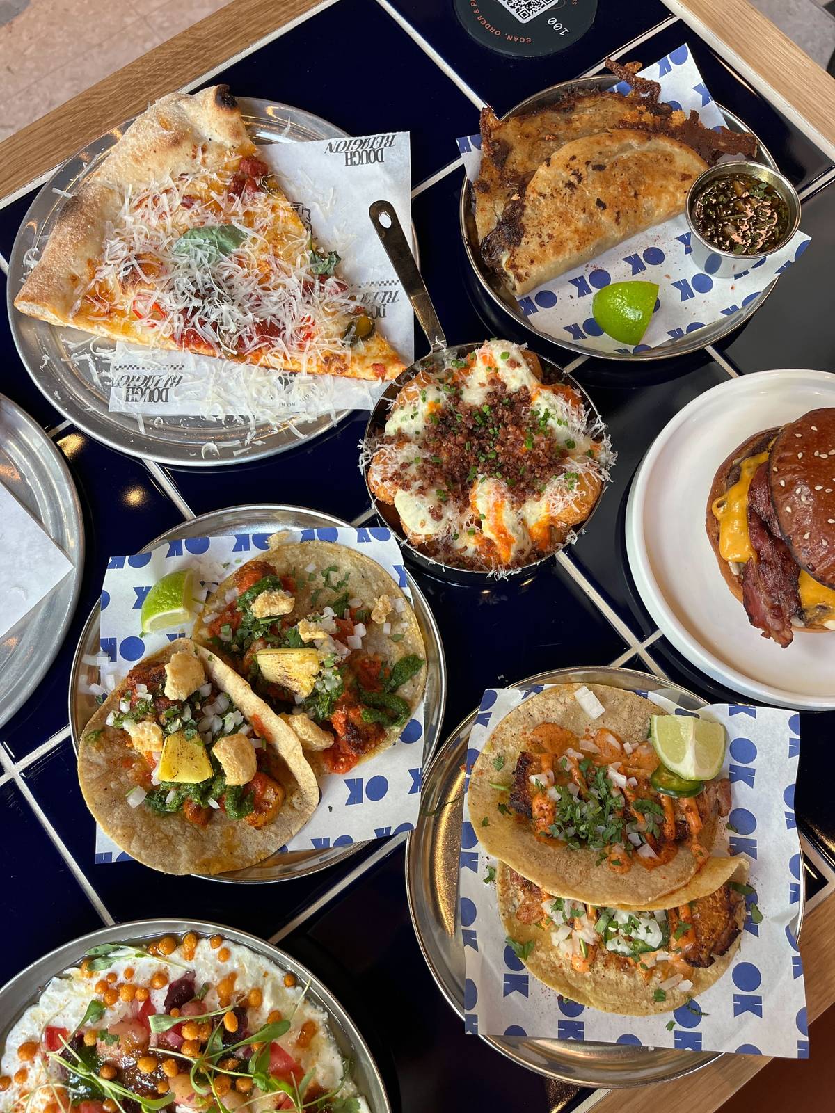 selection of dishes at house of social food hall in manchester including pizza slices, tacos and burgers