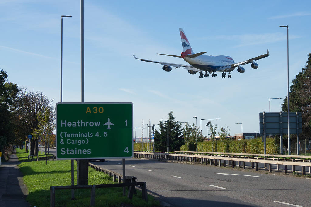 plane flying low above heathrow sign