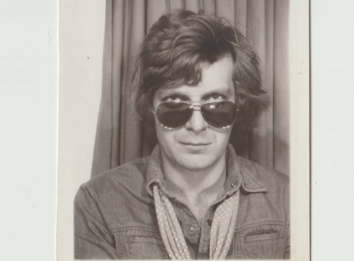 cropped black and white headshot of Tony Wilson in photobooth with sunglasses on