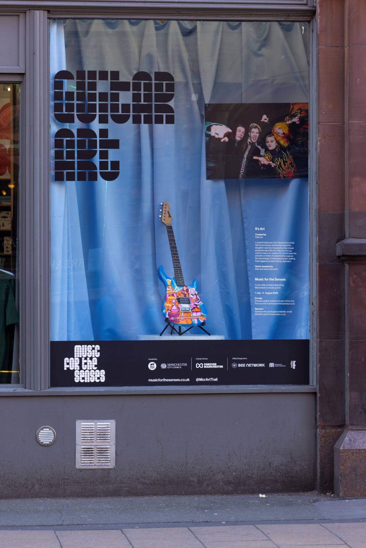 loose articles guitar displayed in window at music for the senses