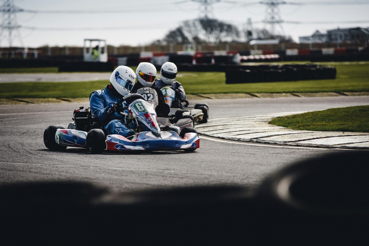 go karting on an outdoor track, 3 racers in action