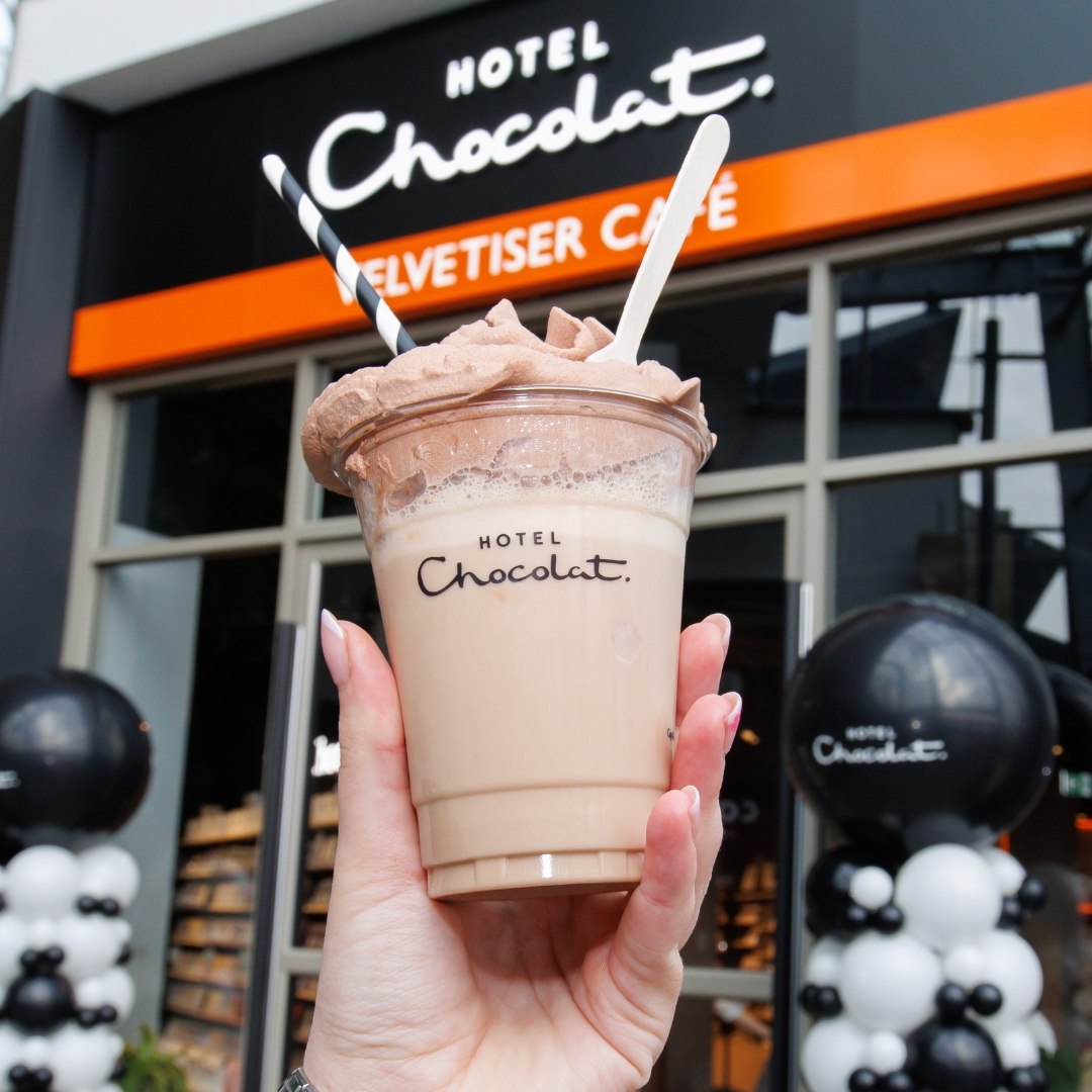 chocolate shake being held up outside hotel chocolat velvetiser cafe