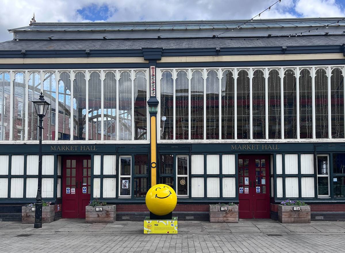smileyworld sculpture outside market hall in stockport
