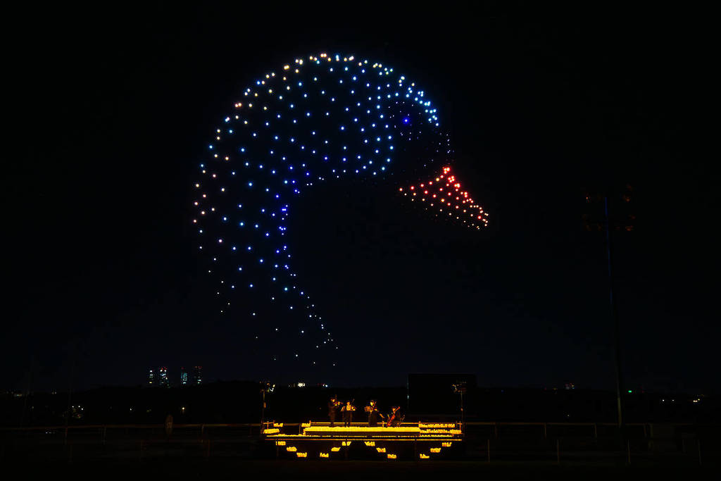 a drone art show creates a giant swan in the sky while a string quartet performs among candles