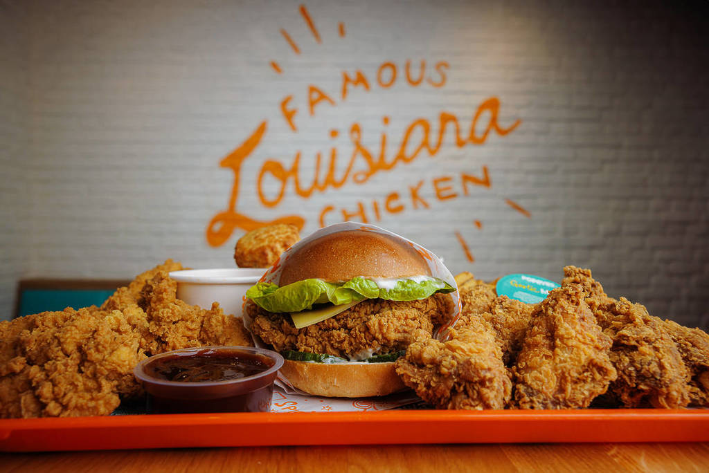 popeyes chicken sandwich, tenders, cajun fries and dips on orange tray