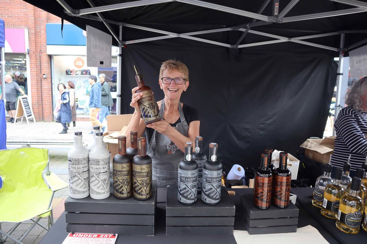 woman at salford rum company stall holding bottle of rum in hands