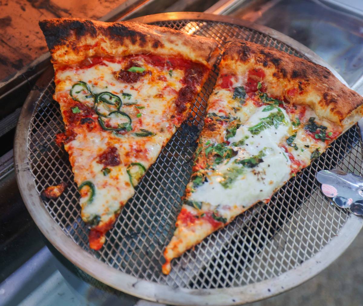 two slices of pizza coming out oven at dough religion
