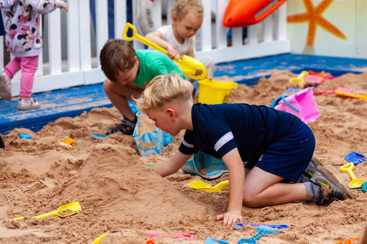 merseybay beach kids playing with buckets and spades stockport