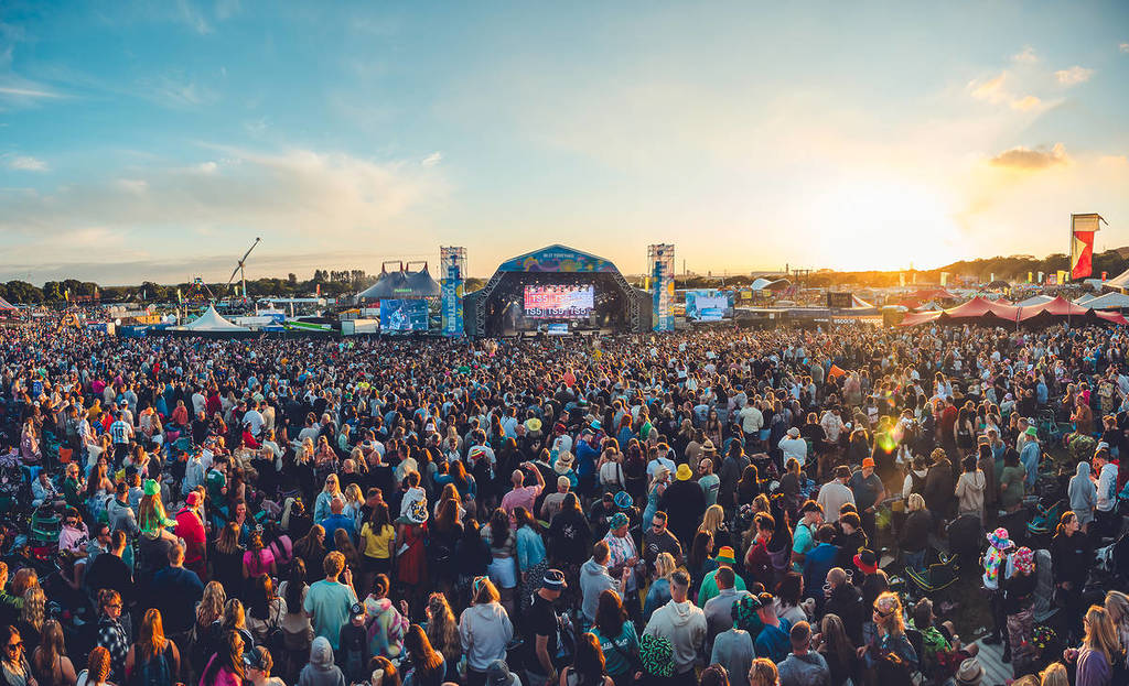 a crowd at the main stage of Together Again Festival while the sun sets