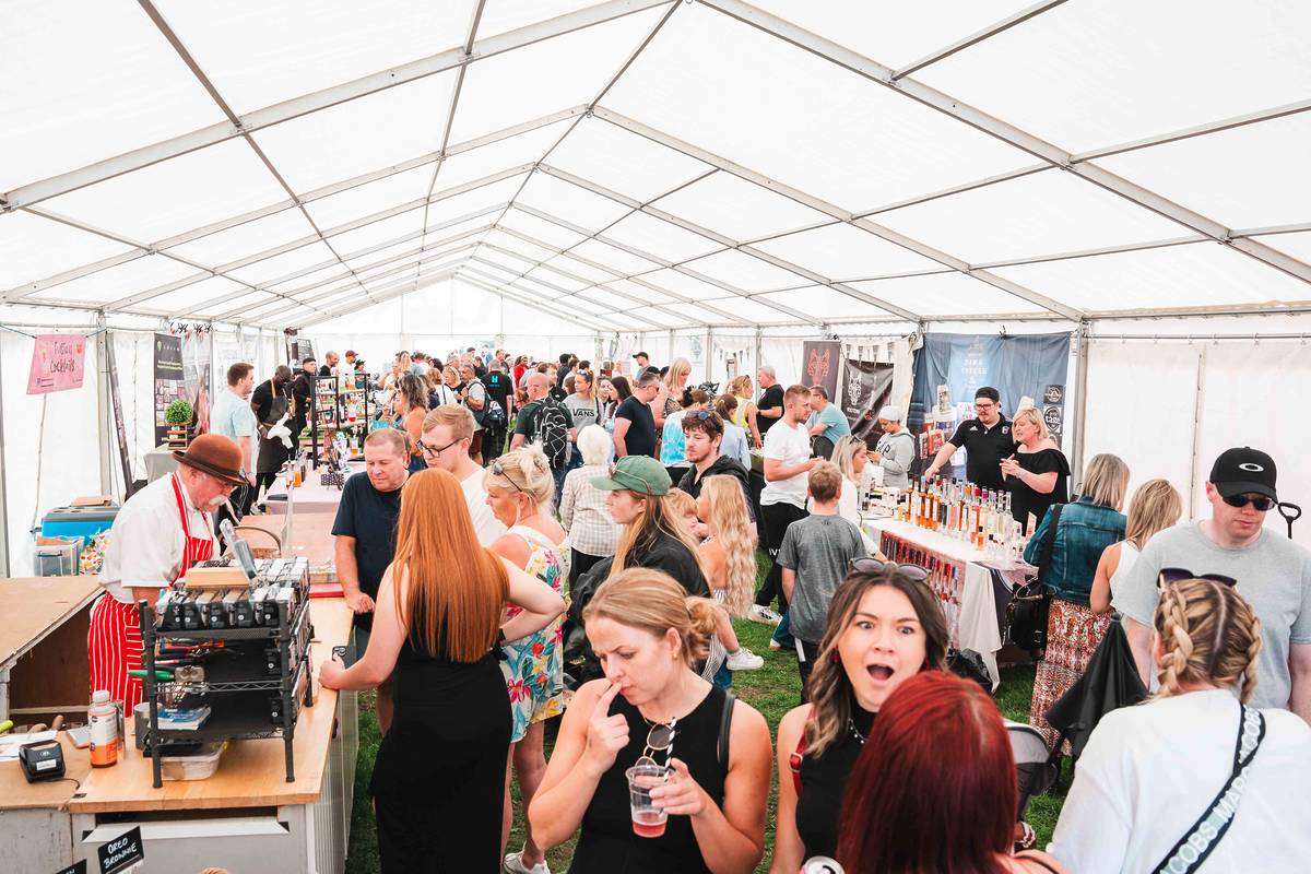 artisan market with people exploring different stalls at heaton park food and drink festival
