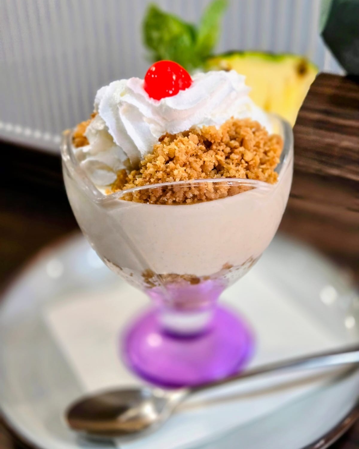 pina colada sundae dessert with whipped cream, slice of pineapple and glace cherry on top