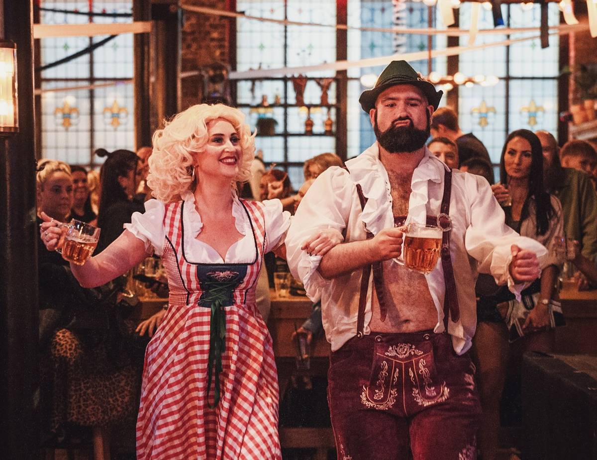 oktoberfest at alberts schloss man and woman walking through with beer