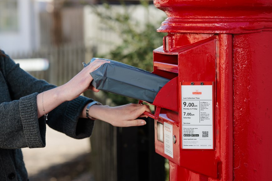 parcel being posted into red postbox