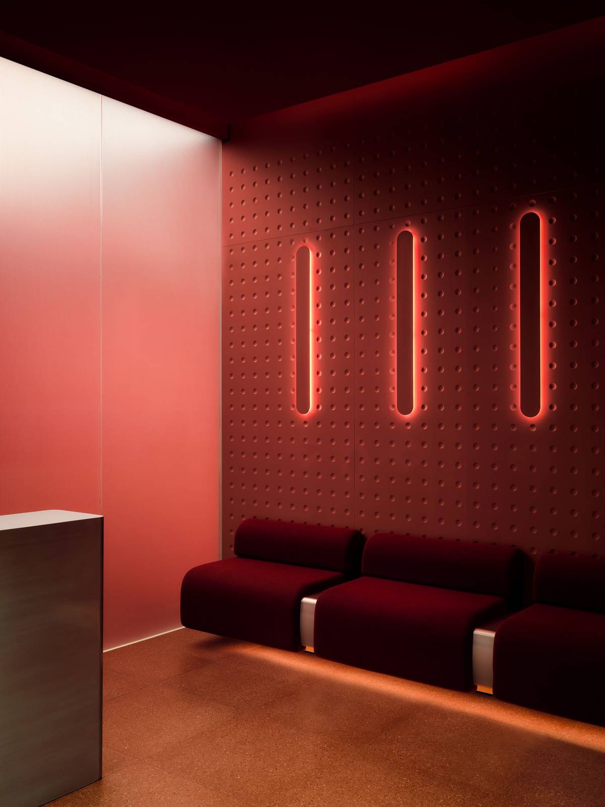 neko health manchester reception area with red sofas and red walls