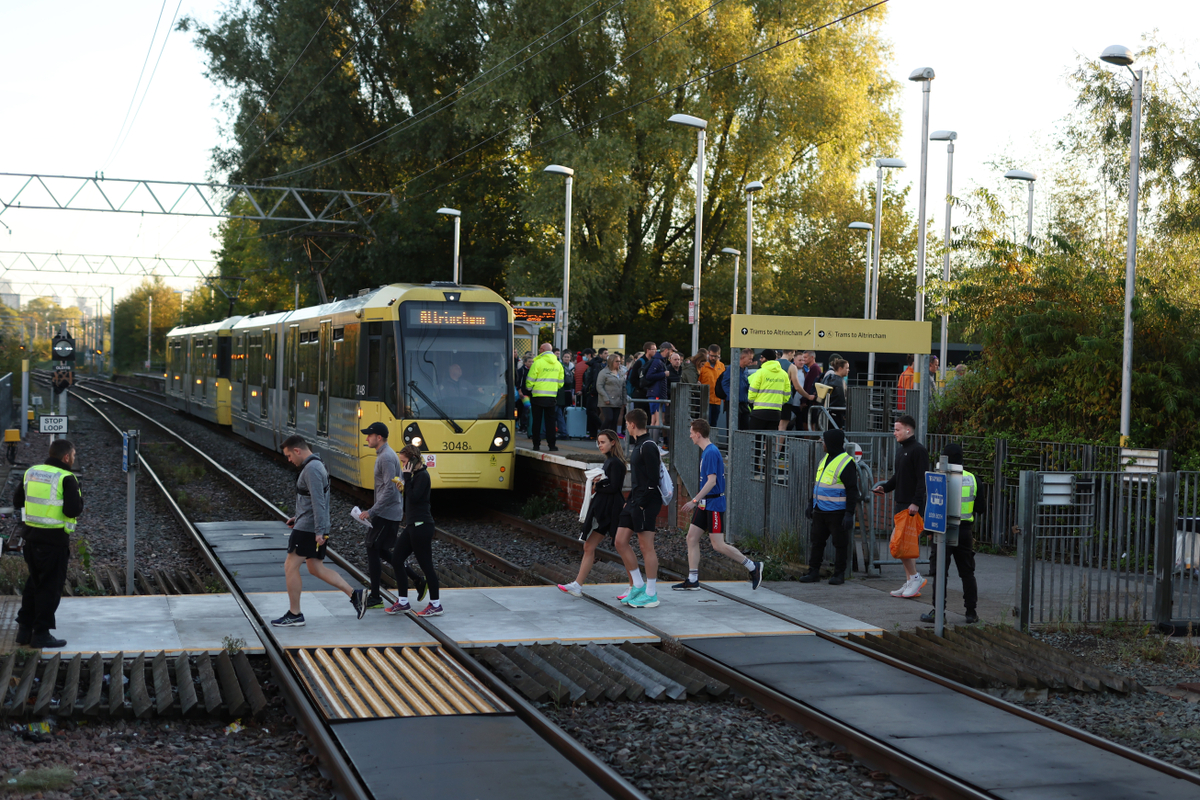 people crossing tram line at manchester half marathon