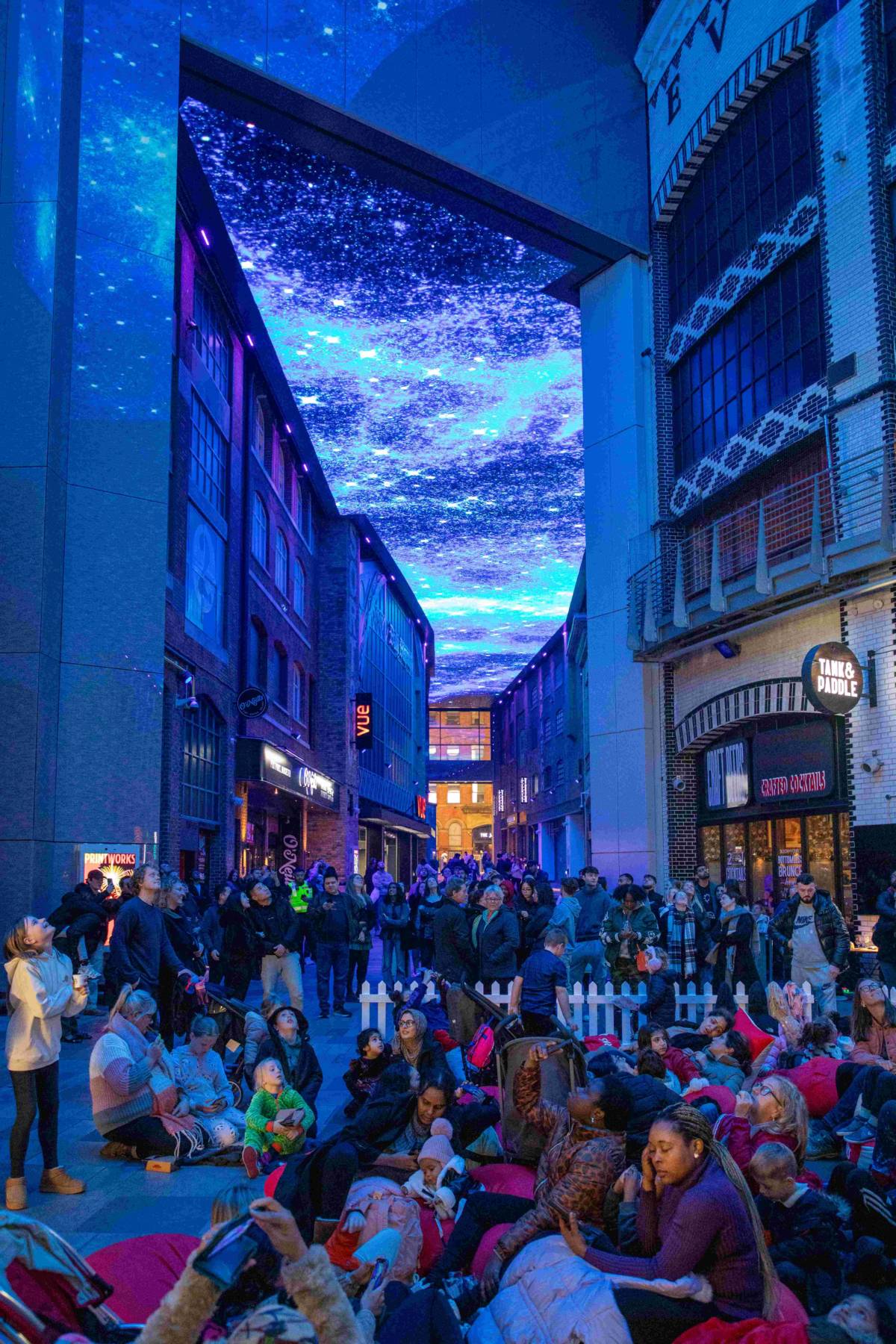 blue misty skies on digital ceiling at printworks with families sat in chill out zone