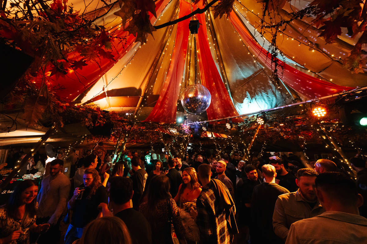 inside the oast house teepee in manchester with red and white striped draping and disco ball hanging from ceiling in centre