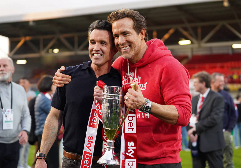 WREXHAM, WALES - APRIL 26: Rob McElhenney and Ryan Reynolds, co-owners of Wrexham AFC, pose for a photo with the trophy following the club's promotion to the Sky Bet Championship during the Sky Bet League One match between Wrexham AFC and Charlton Athletic FC at Racecourse Ground on April 26, 2025 in Wrexham, Wales.