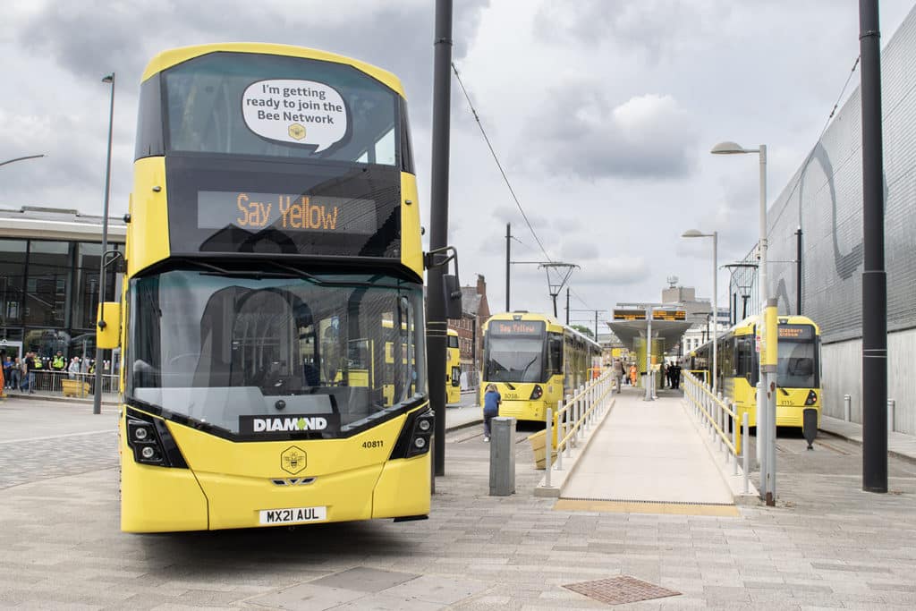 yellow bee network bus next to yellow metrolink trams on platform