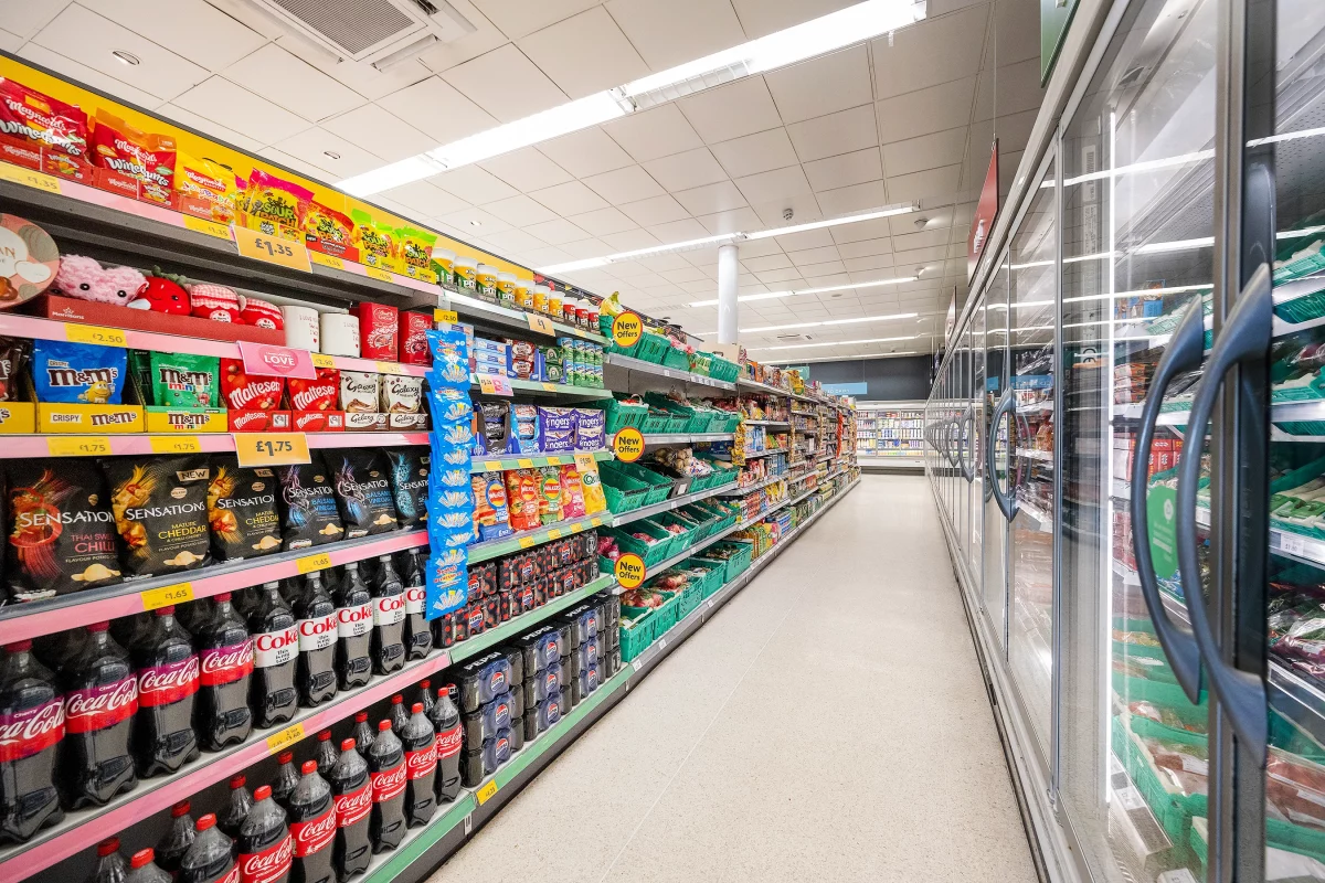 aisle of morrisons supermarket with shelves and fridges